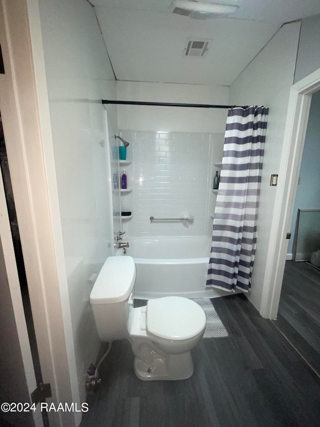 bathroom featuring hardwood / wood-style floors, toilet, and shower / bath combination with curtain