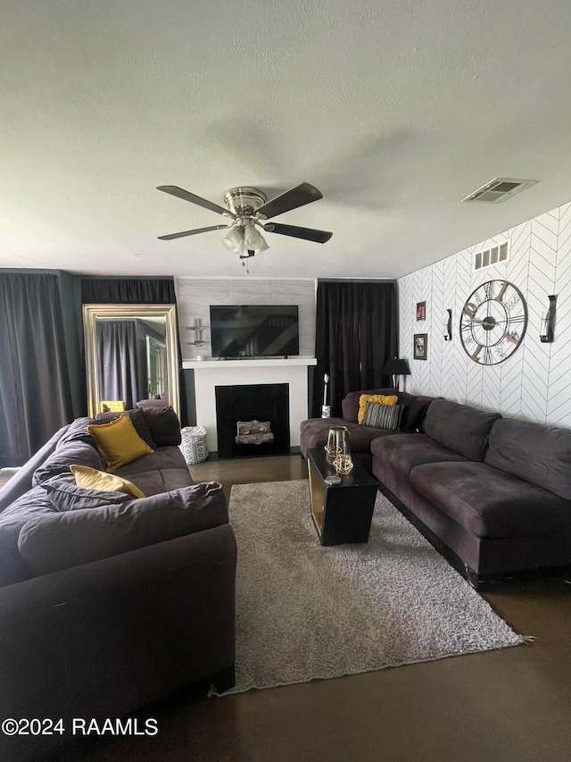 living room with a textured ceiling and ceiling fan