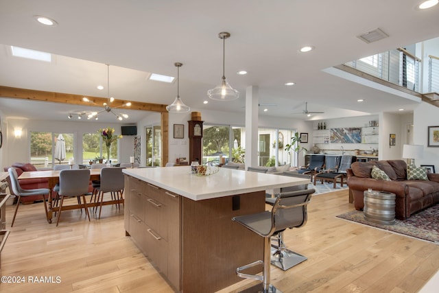 kitchen featuring plenty of natural light, decorative light fixtures, light hardwood / wood-style floors, and a large island