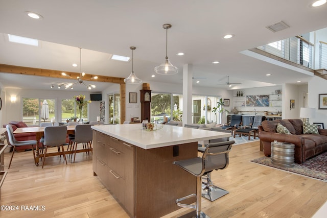 kitchen with light wood-type flooring, visible vents, a center island, and open floor plan