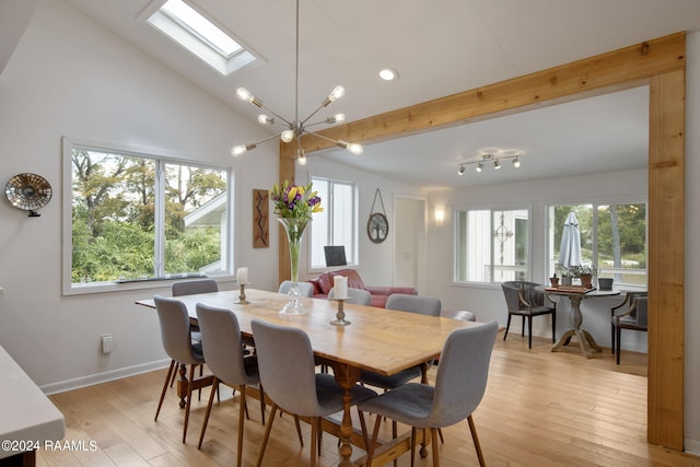 dining room with a skylight, high vaulted ceiling, an inviting chandelier, and light hardwood / wood-style floors