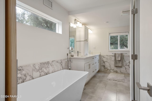 bathroom with a sink, wainscoting, tile walls, a soaking tub, and double vanity