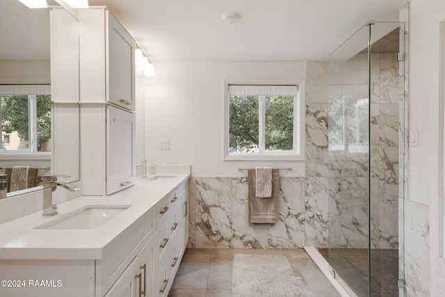 bathroom with vanity, tile walls, tile patterned flooring, and a tile shower