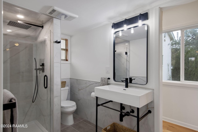 bathroom with hardwood / wood-style flooring, an enclosed shower, tile walls, and toilet