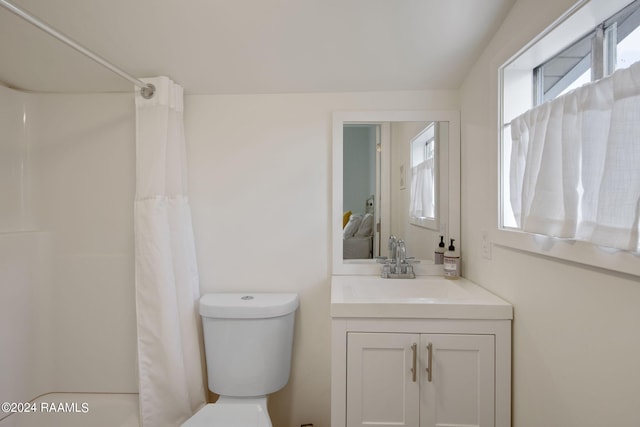 bathroom featuring curtained shower, vanity, and toilet