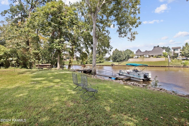 view of yard featuring a water view and a dock