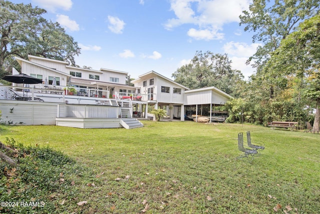 rear view of property featuring a yard and a deck