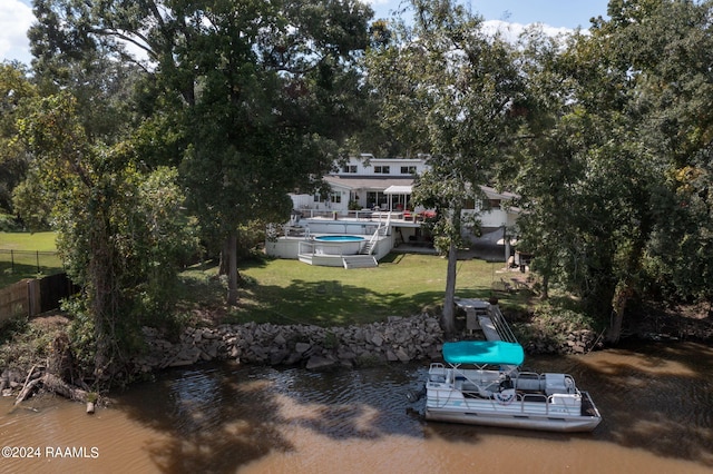 dock area with fence, a fenced in pool, a yard, and a water view