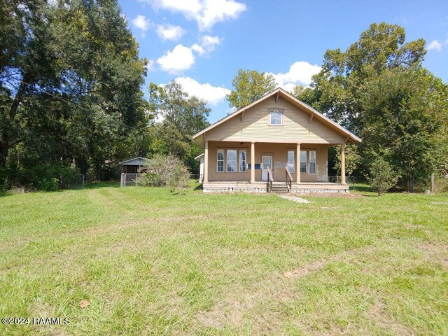 view of front of property featuring covered porch and a front yard