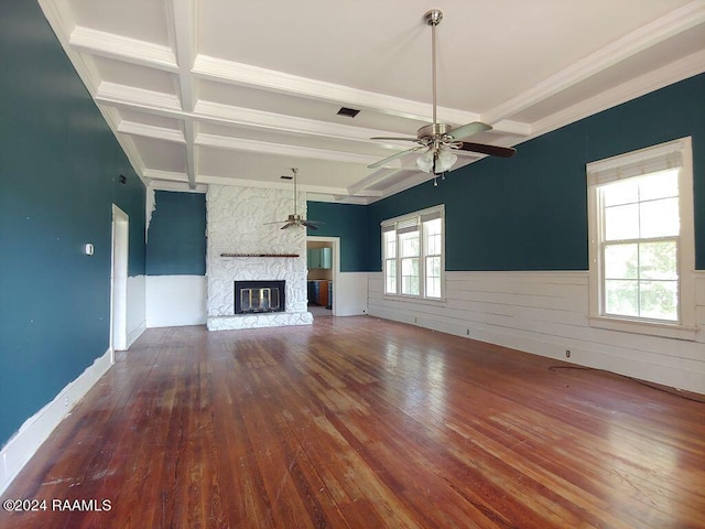 unfurnished living room featuring wood-type flooring, a fireplace, beam ceiling, and ceiling fan