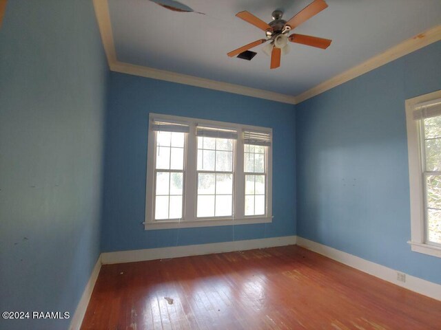 empty room with ceiling fan, ornamental molding, and wood-type flooring