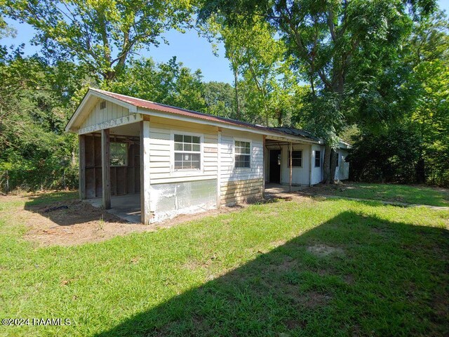 exterior space featuring a yard and a sunroom