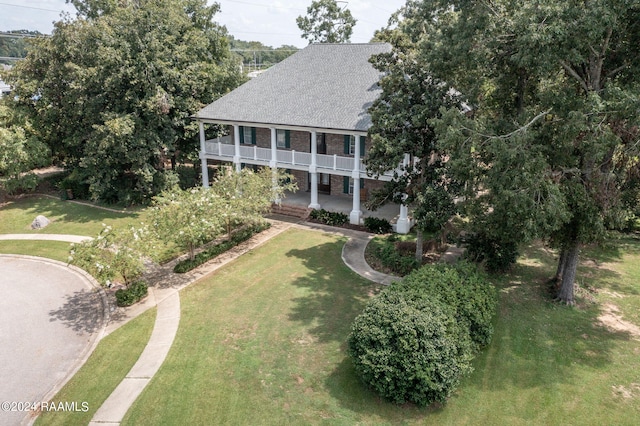 view of front facade featuring a balcony and a front lawn