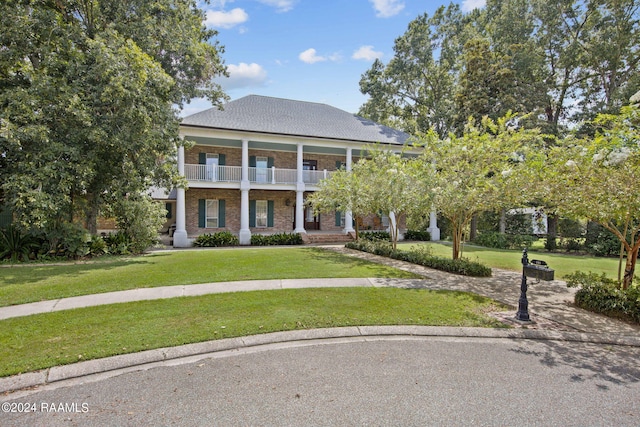 neoclassical / greek revival house with a balcony and a front lawn