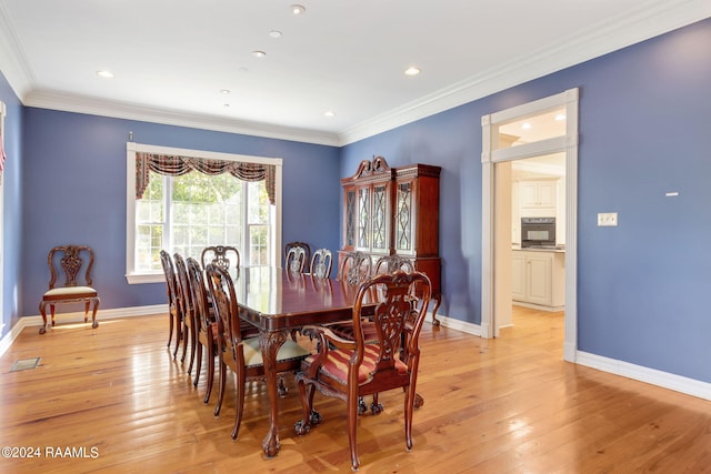 dining area with light hardwood / wood-style flooring and ornamental molding