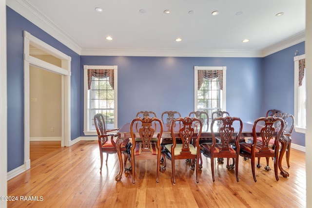 dining room with crown molding and light hardwood / wood-style floors