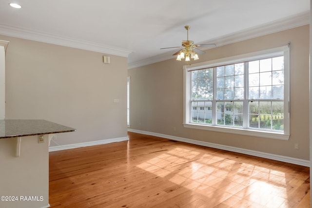 unfurnished dining area with light wood-type flooring, crown molding, and ceiling fan