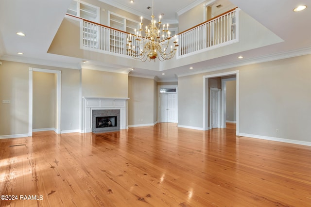 unfurnished living room featuring ornamental molding, light wood-type flooring, and a fireplace