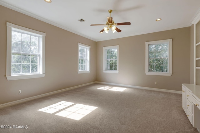 spare room with ornamental molding, ceiling fan, and light carpet