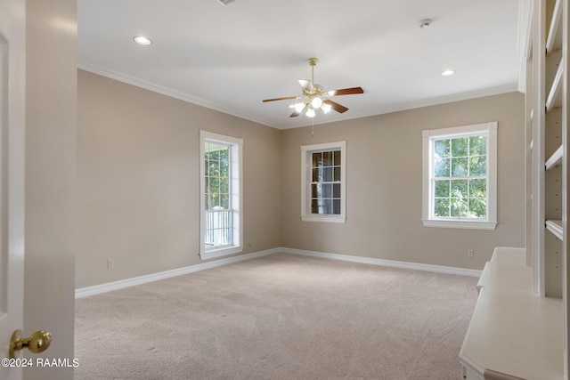 carpeted empty room with ceiling fan and ornamental molding