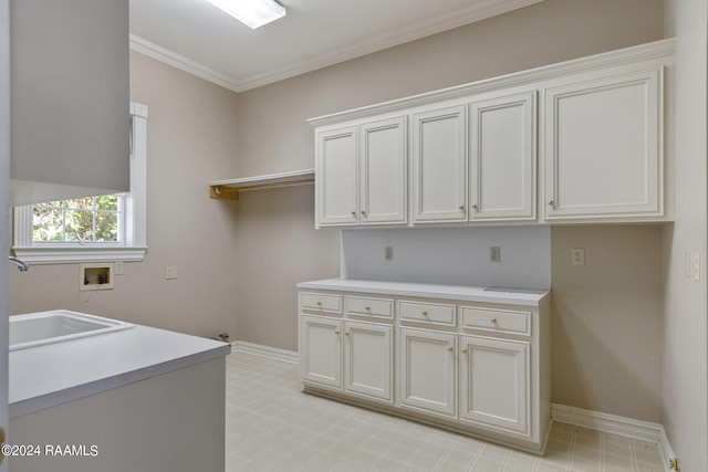 washroom featuring ornamental molding, sink, washer hookup, and cabinets