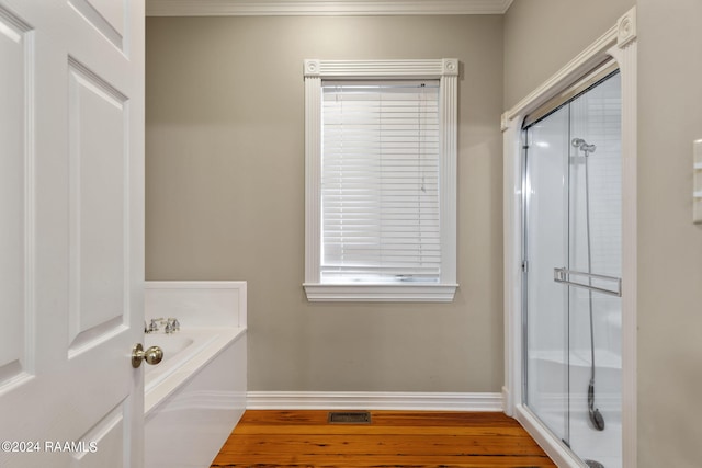 bathroom featuring shower with separate bathtub, crown molding, and hardwood / wood-style flooring