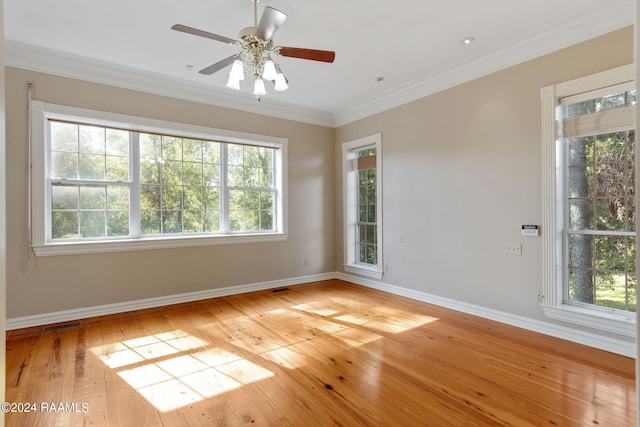 unfurnished room with a healthy amount of sunlight, light hardwood / wood-style floors, ornamental molding, and ceiling fan