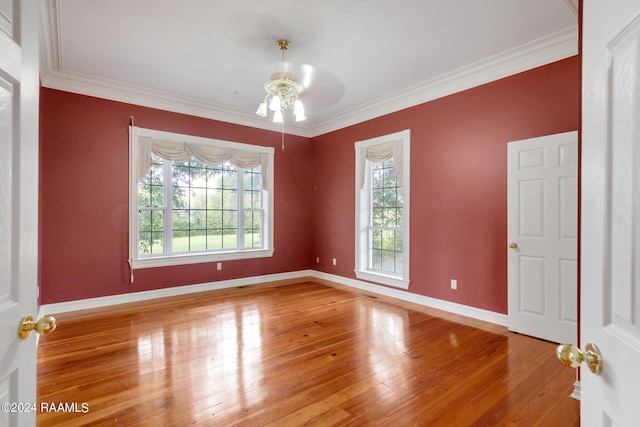 empty room with a wealth of natural light, ceiling fan, hardwood / wood-style flooring, and crown molding