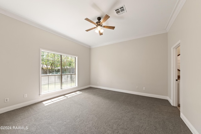 empty room featuring crown molding, dark colored carpet, and ceiling fan