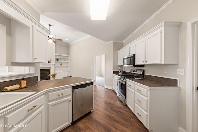 kitchen featuring stainless steel appliances, white cabinetry, tile counters, and dark wood-type flooring