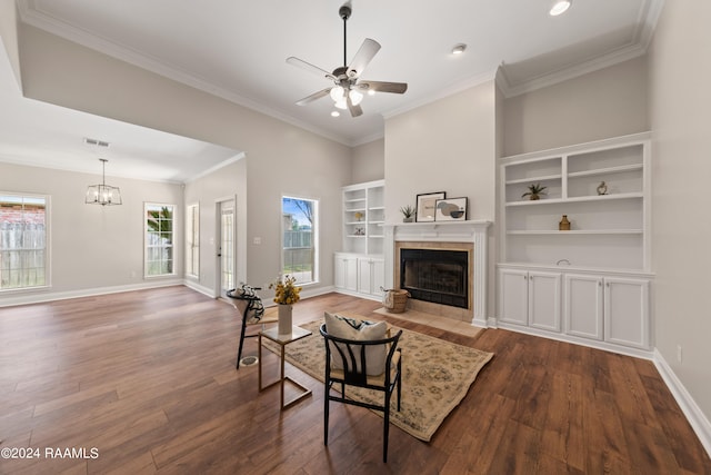 living room with ceiling fan with notable chandelier, a fireplace, dark hardwood / wood-style flooring, and a wealth of natural light