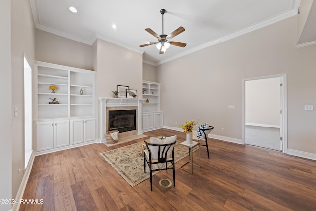 living room with ceiling fan, hardwood / wood-style flooring, a fireplace, and a high ceiling