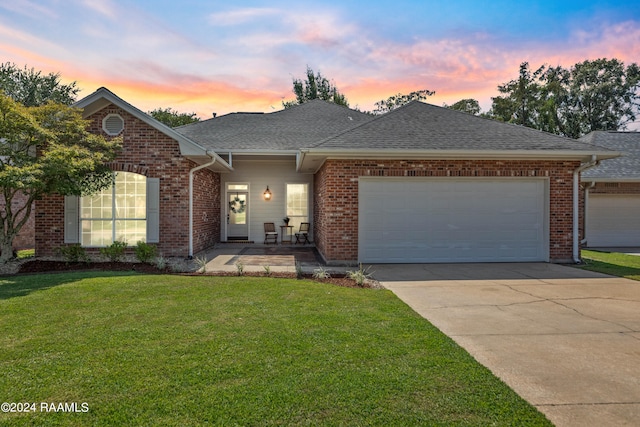 view of front of property featuring a garage and a lawn