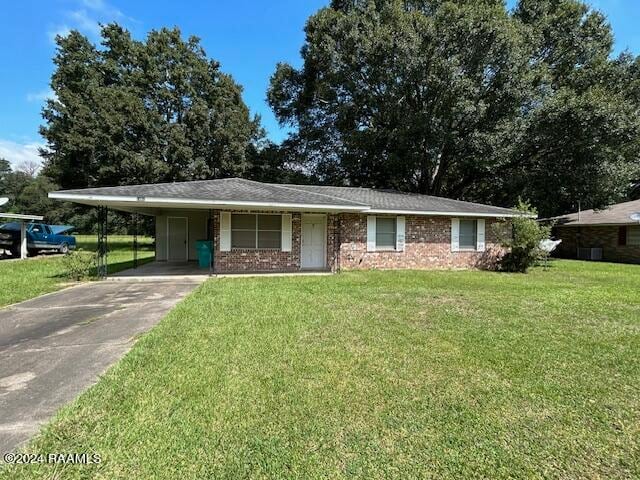 ranch-style house featuring a carport and a front yard