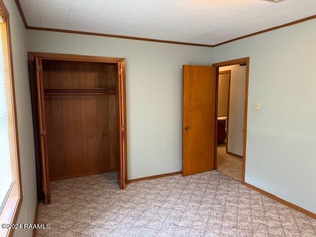 unfurnished bedroom featuring crown molding and a closet