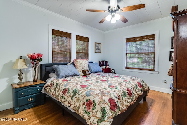 bedroom with ceiling fan, hardwood / wood-style flooring, and crown molding