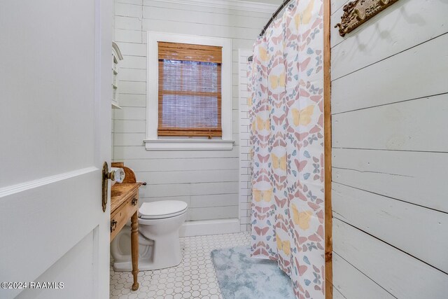 bathroom with wooden walls, toilet, and a shower with shower curtain