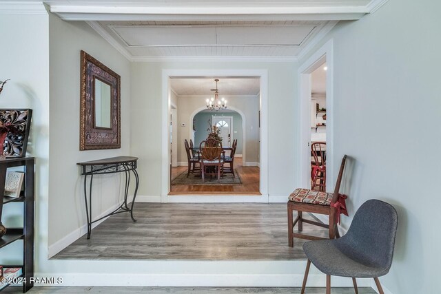 interior space with ornamental molding, a chandelier, and hardwood / wood-style floors