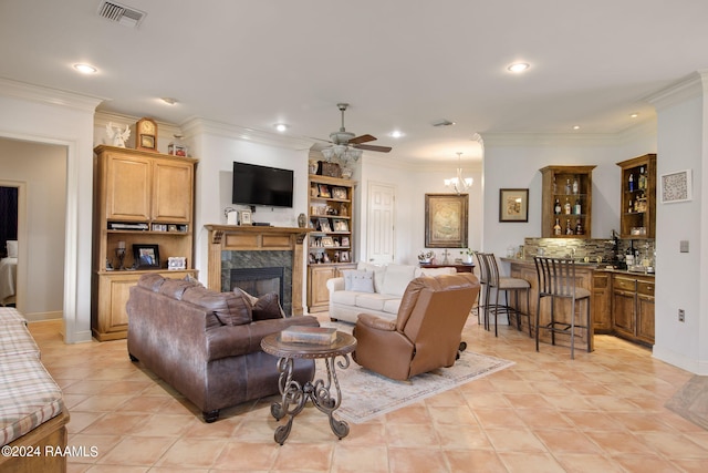 tiled living room featuring ceiling fan with notable chandelier, a fireplace, and ornamental molding