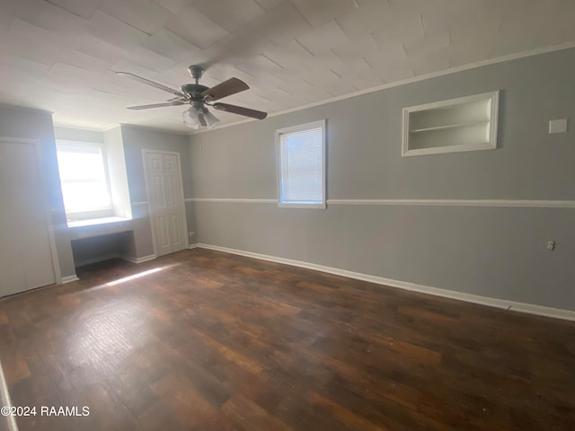 empty room with dark wood-type flooring, crown molding, and ceiling fan