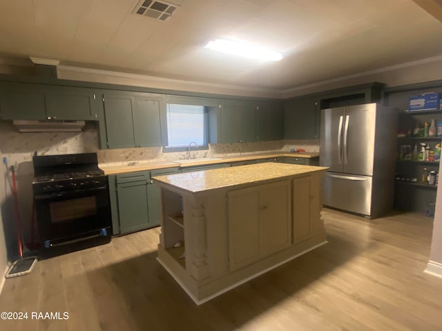 kitchen with black gas range, extractor fan, stainless steel fridge, a center island, and light hardwood / wood-style floors