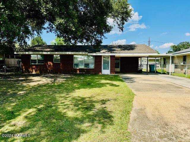 single story home with a front yard and a carport