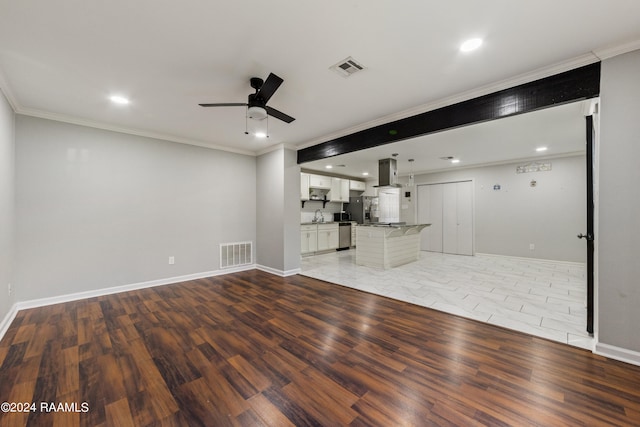 unfurnished living room featuring ornamental molding, hardwood / wood-style floors, ceiling fan, and sink