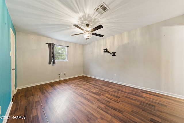 spare room featuring dark wood-type flooring and ceiling fan