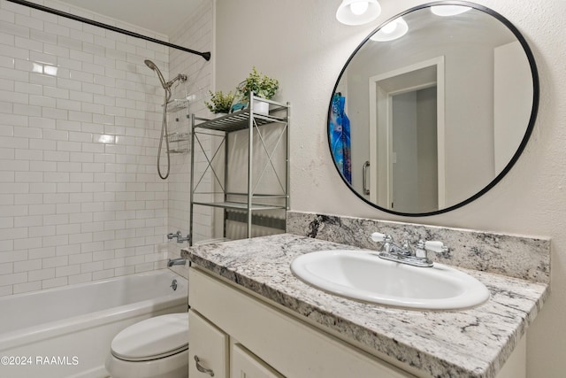 full bathroom with vanity, tiled shower / bath combo, and toilet