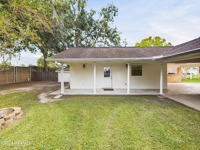 rear view of property with a lawn and a patio