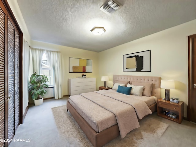 carpeted bedroom featuring a textured ceiling