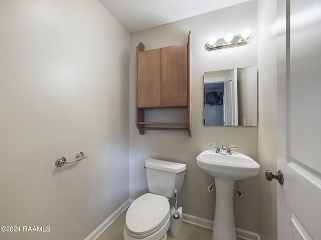 bathroom with a textured ceiling and toilet