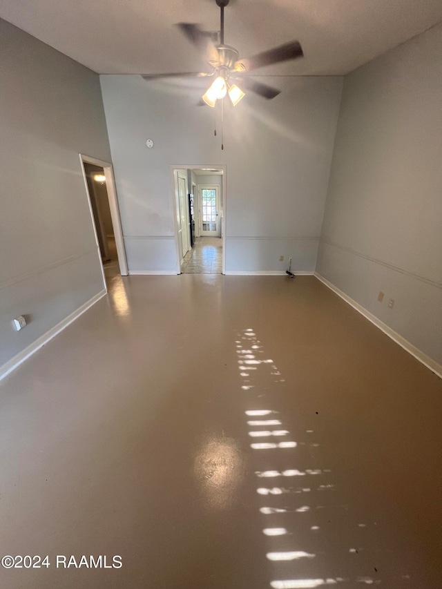 spare room featuring vaulted ceiling, ceiling fan, and concrete flooring