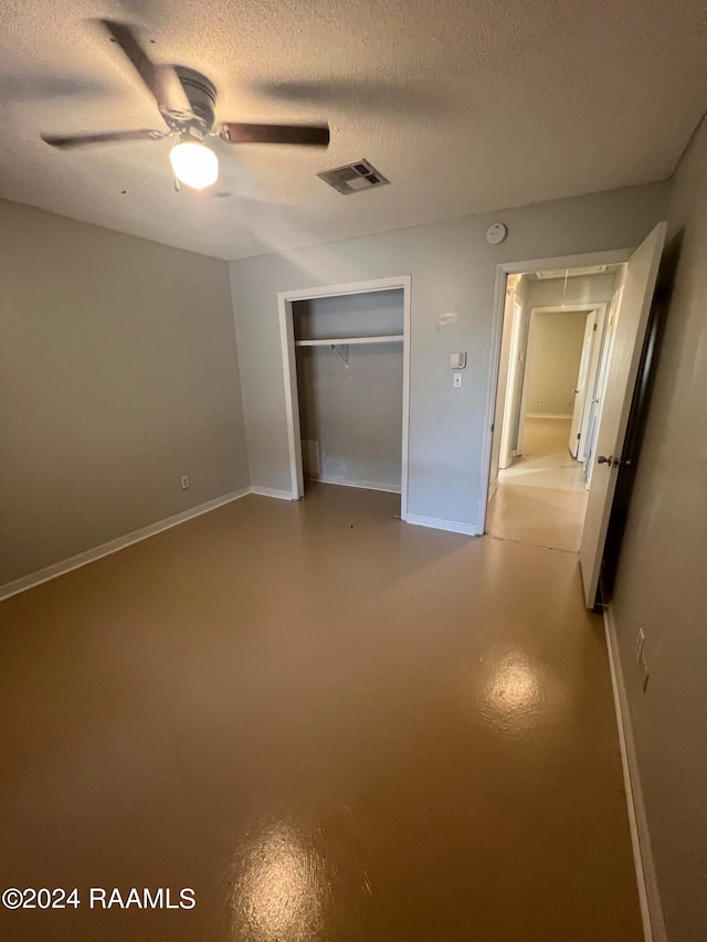 unfurnished bedroom featuring a closet, concrete flooring, ceiling fan, and a textured ceiling